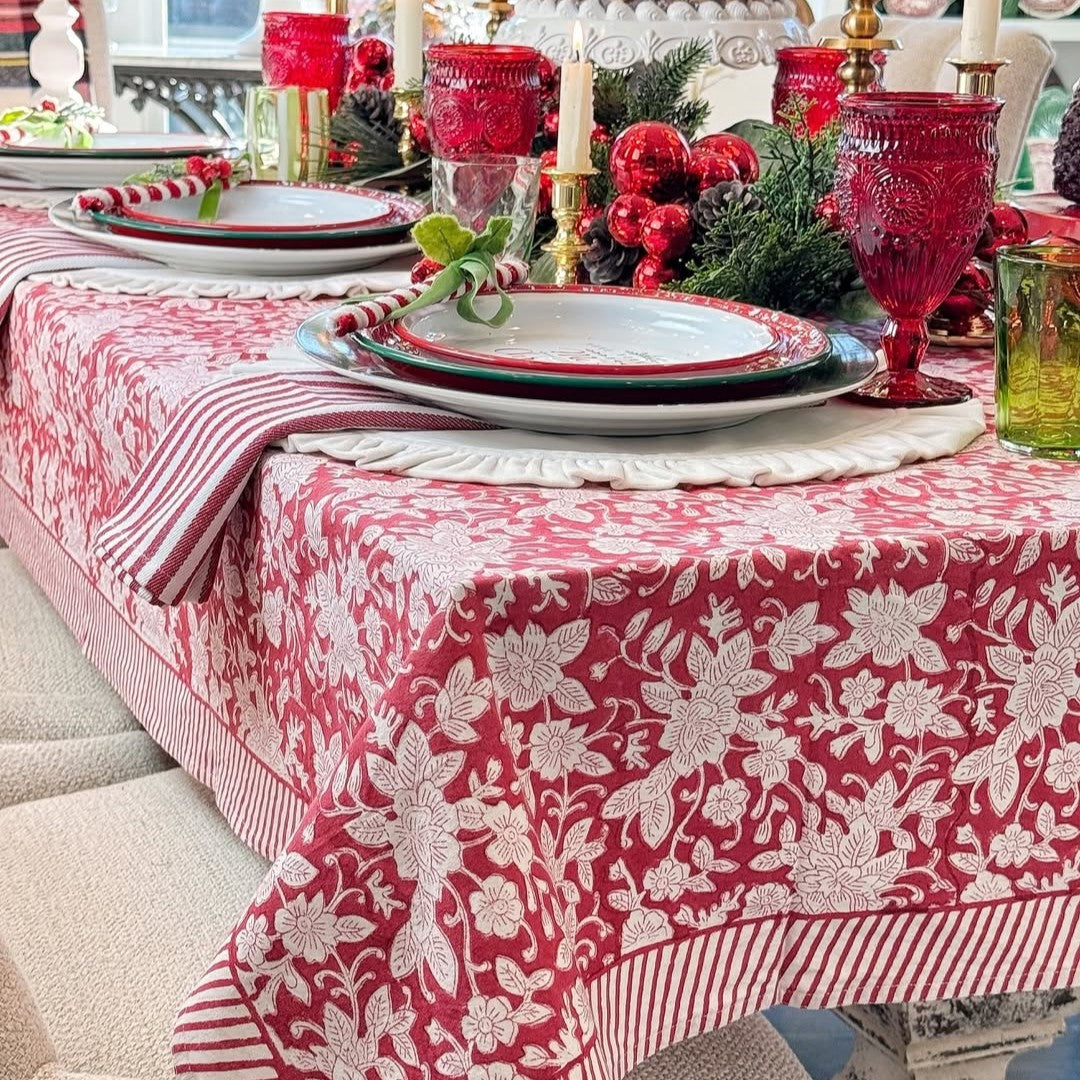 Closeup of Red holiday floral patterened tablecloth, hand block printed on premium cotton for family heirloom.