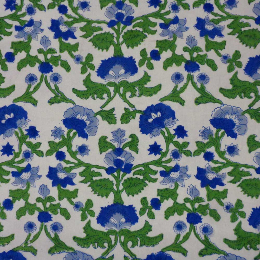 Close up of hand block printed blue floral pattern on cotton tablecloth showing fabric texture and floral pattern