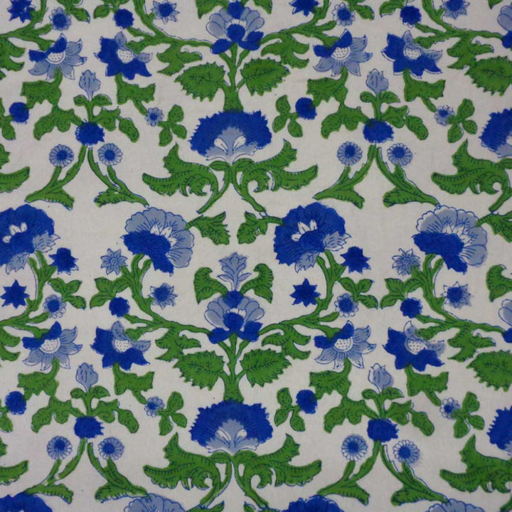 Close up of hand block printed blue floral pattern on cotton tablecloth showing fabric texture and floral pattern