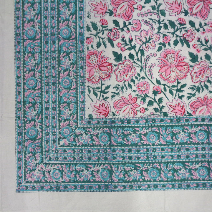 Corner detail of pink green floral pattern and intricate blue green border