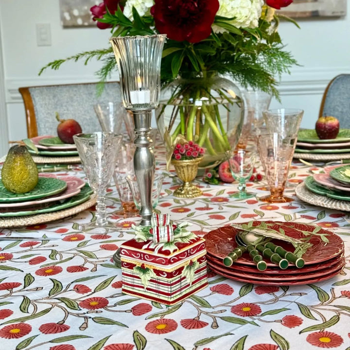 Christmas dinner holiday tablecloth set on a large table with beaded fruits and fresh florals