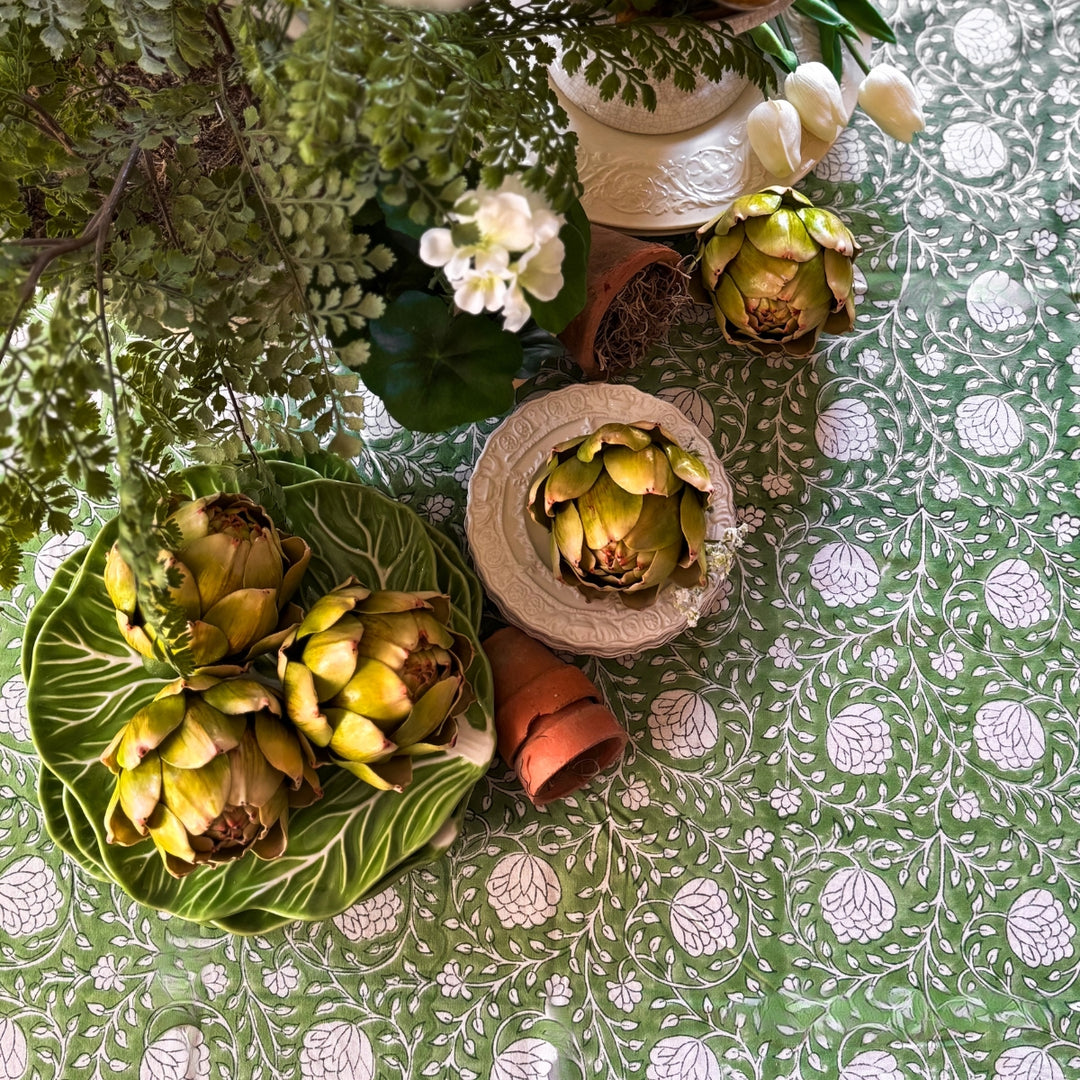 Close-up of a rectangular Eden tablecloth corner showing the hand block printed green and white floral