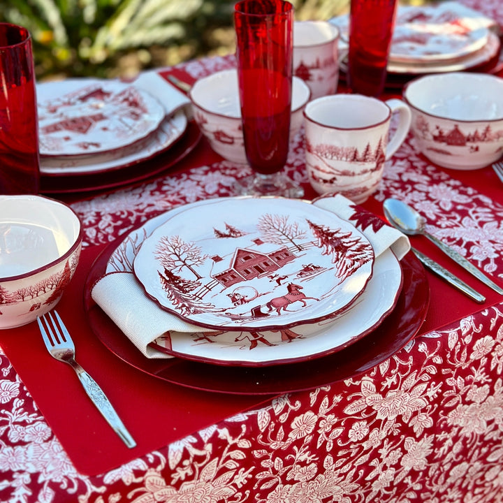 A winter Tablescape with red and white floral Block printed Indian table cloth with white dishes and red tall glasses