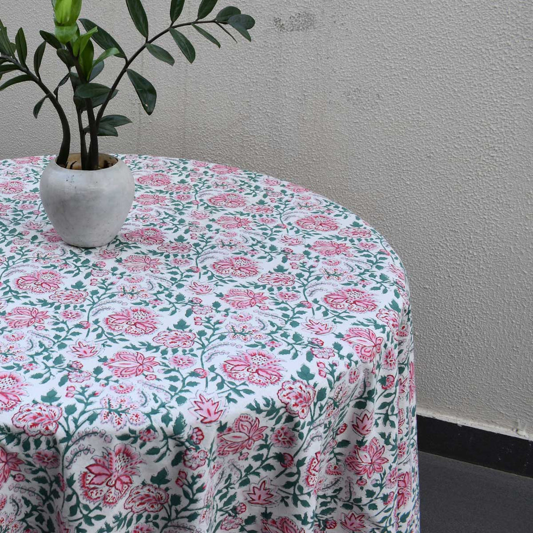 Side view of Pink green floral round table cover with a small plant vase for casual dining