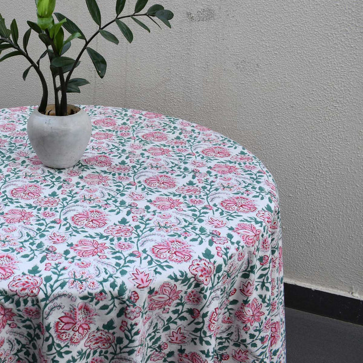 Side view of Pink green floral round table cover with a small plant vase for casual dining