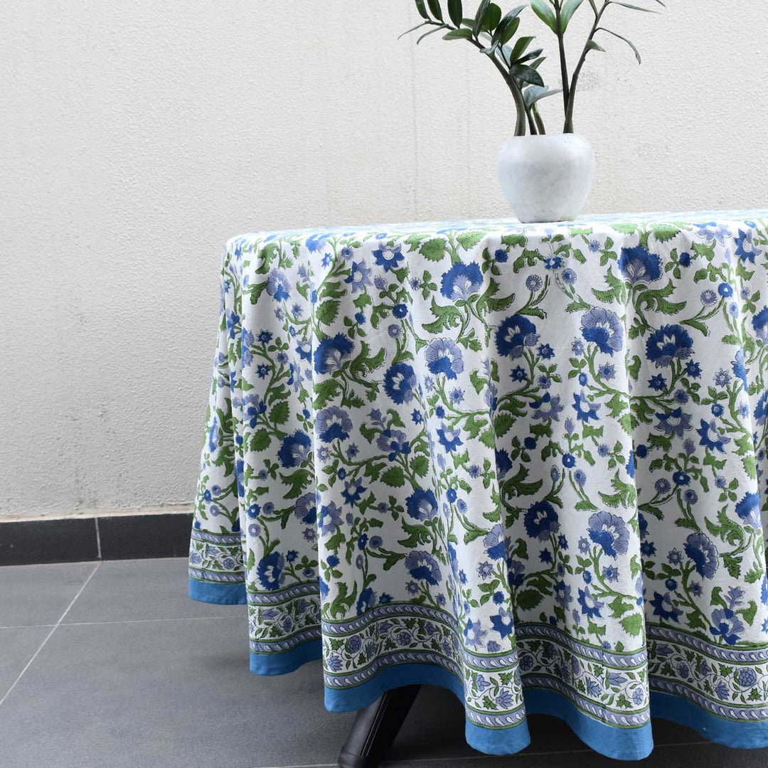 Side angle of round hand block printed tablecloth showing fabric drape and intricate floral border