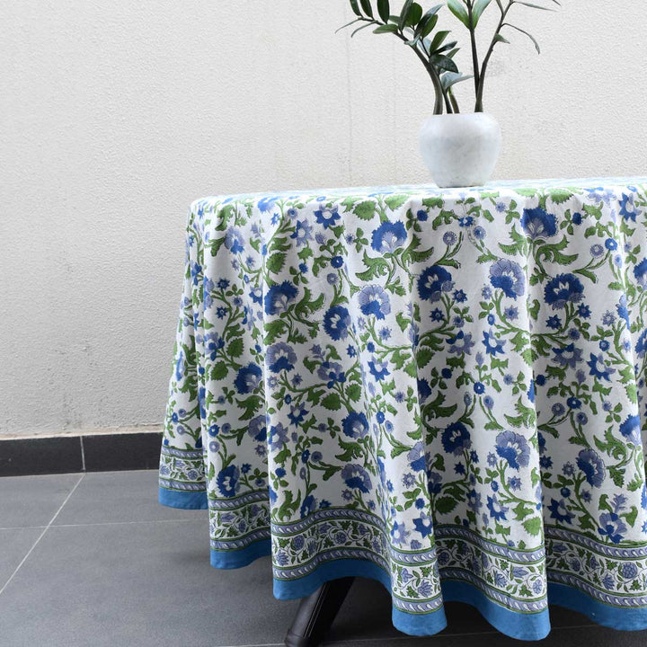 Side angle of round hand block printed tablecloth showing fabric drape and intricate floral border