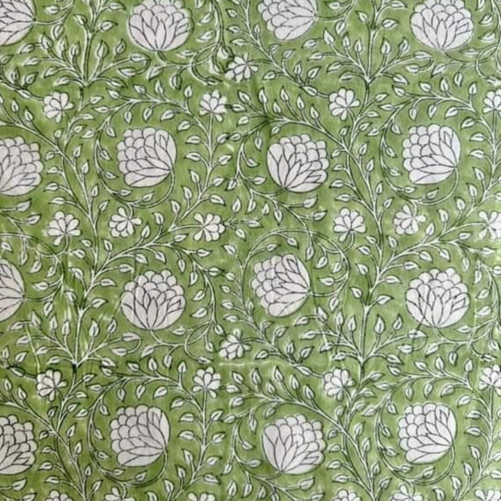 Close-up of a Eden tablecloth corner showing the hand block printed green and white floral pattern and natural cotton fabric texture