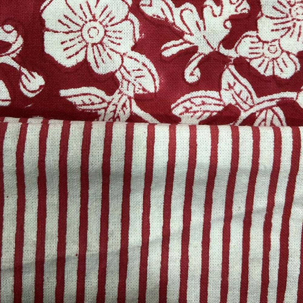 Close-up of a red and white striped table napkin with a floral pattern in the corner.